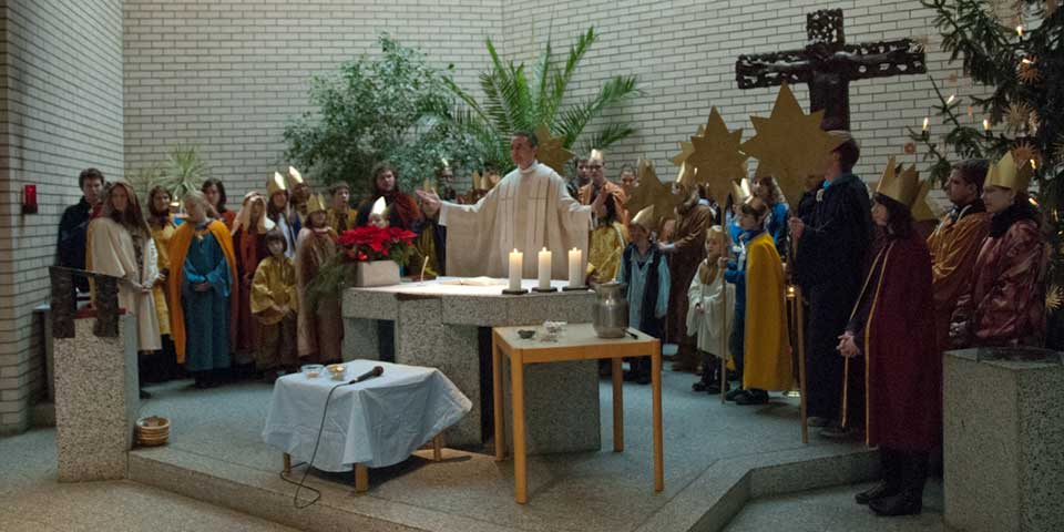 Die Sternsinger mit Pfarrer Sauer versammelt um den Altar Sternsinger 2012
