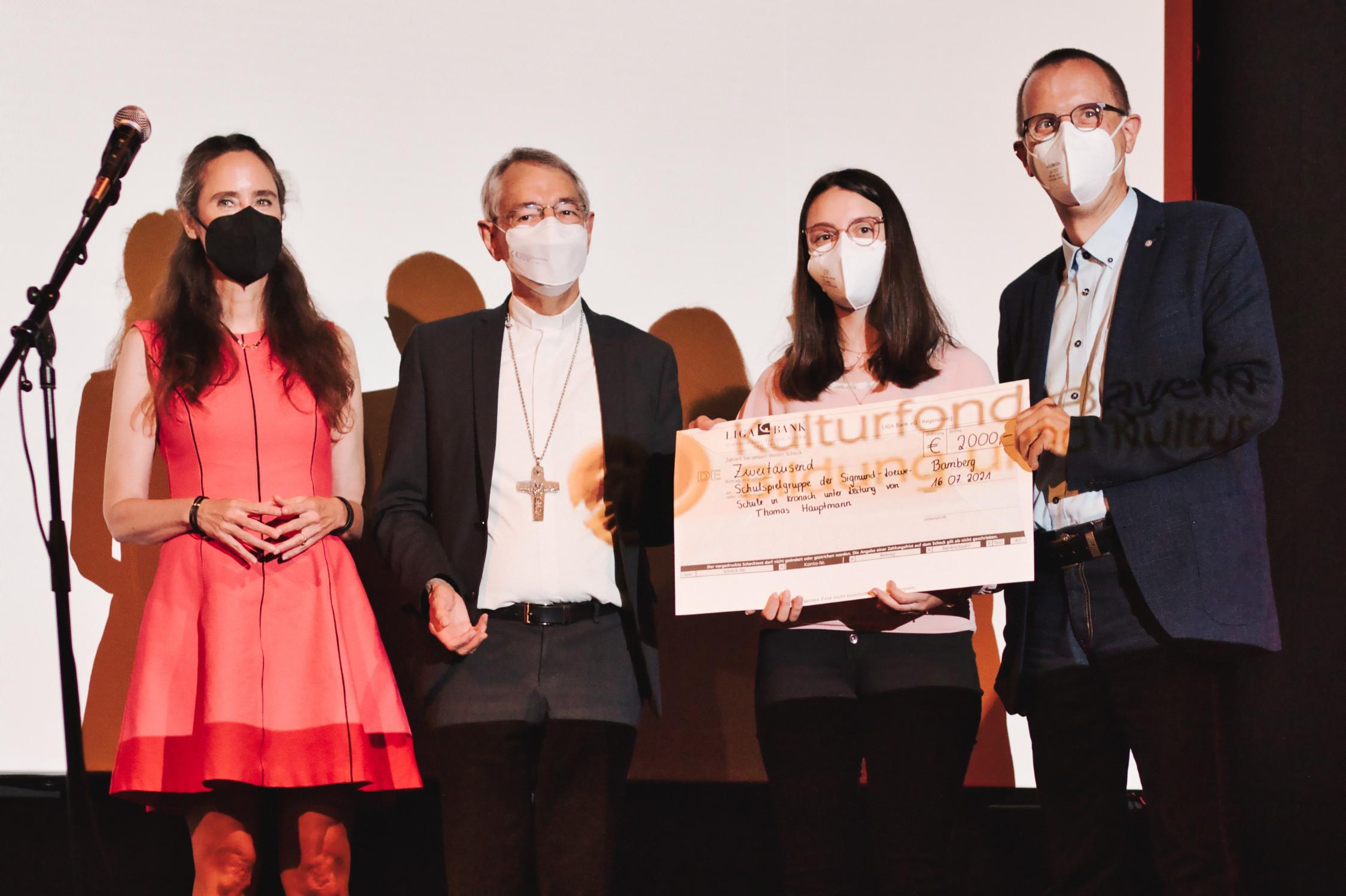 Schirmherrin Tanja Kinkel, Erzbischof Ludwig Schick und die Vertreter des Kronacher Gewinnerteams, Alina Gäßlein und Thomas Hauptmann, bei der Übergabe des Gewinnerschecks Kirchenstorys