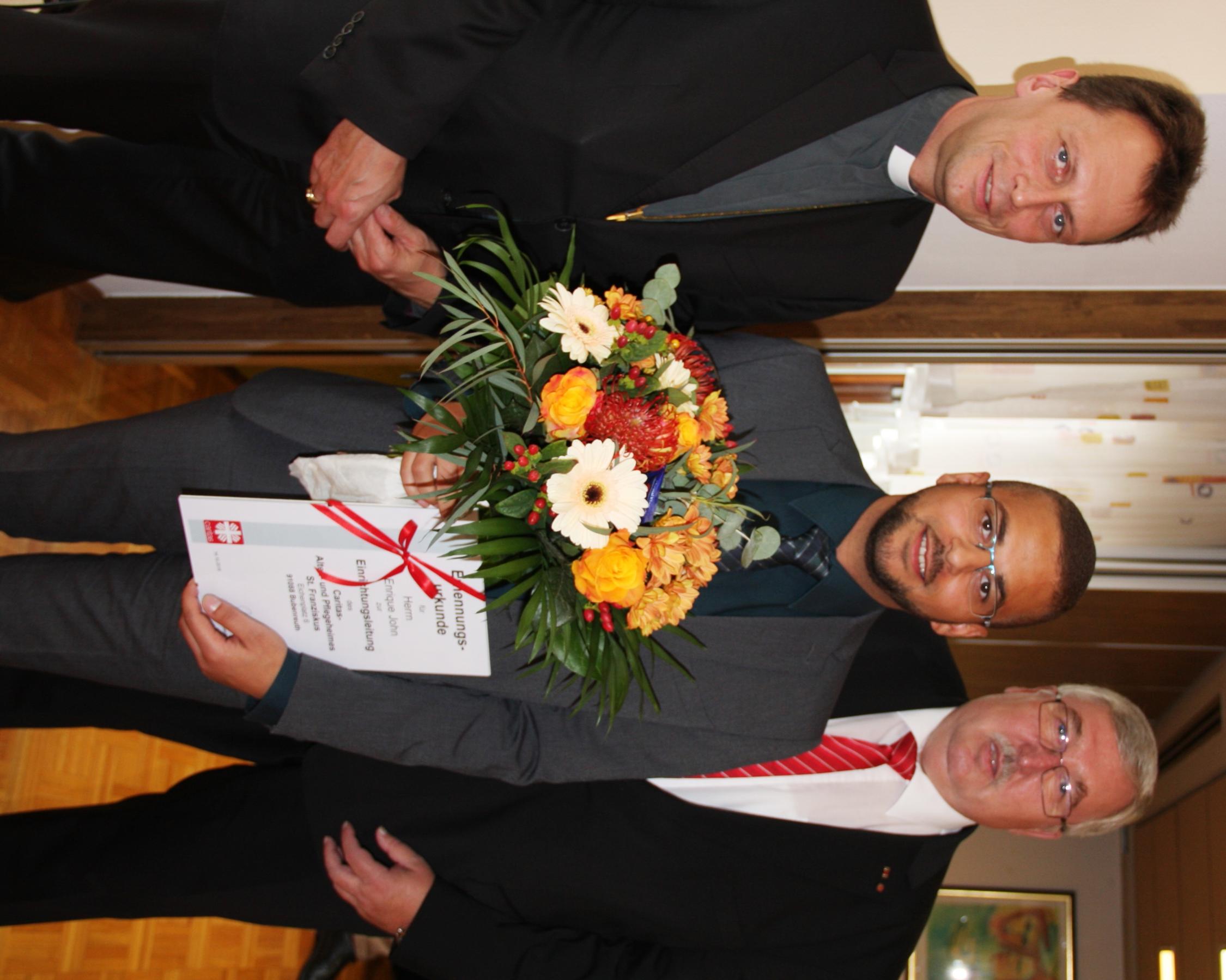 Weihbischof Herwig Gössl (li.) und Diözesan-Caritasdirektor Gerhard Öhlein (re.) überreichten Enriqúe John die Ernennungsurkunde. AH Bubenreuth Einführung John