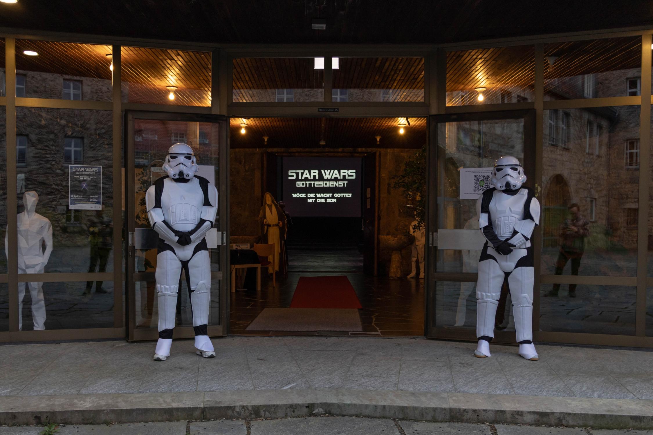 Zwei Sturmtruppler, die die Besucherinnen und Besucher vor dem Eingang in die Kirche erwarten Star Wars-Gottesdienst